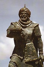 A metal statue depicting a 7th-century Arab general wearing a turban and carrying an unsheathed sword