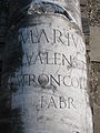 A broken stone column with inscriptions
