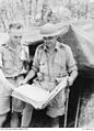 Lieutenant Colonel Frederick Galleghan examining a map with Sergeant Heckendorf outside the command post at Gemas.