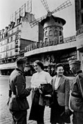 Two German soldiers, with two women, in front of the Moulin Rouge, during the Nazi occupation, June 1940.