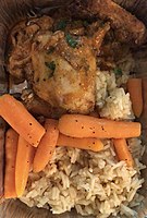 A meal consisting of chicken served with carrots and rice