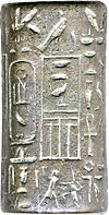 Small cylinder of grey silver with hieroglyphic signs inscribed on it