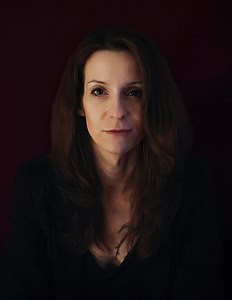 Porträt einer Frau mit dunklen Haaren in einem dunklen Raum