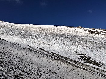 Tooth-like snow forms on a medium-steep slope of a mountain