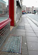 A pavement light set into the pavement outside a store (close-up)