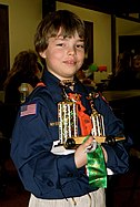 A Cub Scout holds a winning pine car