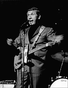 Buck Owens playing the guitar at a 1968 state fair music performance.