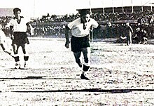 Camille Cordahi running towards the camera, with another player standing in the background
