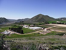 An overview photo of buildings and fields at the Lucky Peak Nursery from a hillside above it