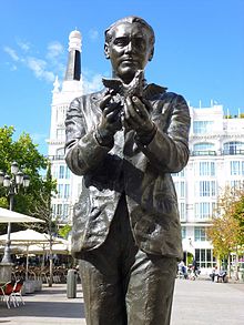 A bronze statue of García Lorca, hands in front of him, a lark taking flight from his hands.