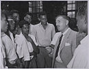 Naipaul attended the government-run Queen's Royal College (QRC), a high school, Port of Spain from 1942 to 1950. Shown here are some older students at QRC talking to a visitor in 1955.