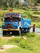 Driver washing decorated truck near Bangalore.