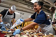 YNC Inez Cannon adds the topping to Thanksgiving dinner pie aboard USS Theodore Roosevelt (CVN-71).