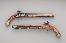 Two flintlock pistols inlaid with salmon-colored coral