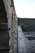 The road bridge adjacent to the aqueduct. Pedestrians are shown for scale.