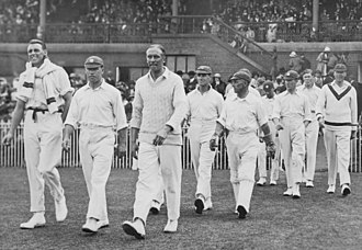 Photograph of England team walking onto the Melbourne Cricket Ground with fans watchingfrom the stands