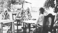 Major General Edward King discusses terms of surrender with Japanese officers.