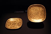 A pair of square lobed gold dishes with chased insects, flowers and knotted ribbons