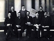 Formal indoor photo of eight men