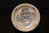 A blue and white stoneware plate with floral motif (cobalt-blue pigment over white slip), manufactured in kilns in Gongxian, Henan.
