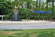 Round, outdoor area with blue flags and a statue