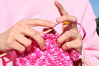 Knitting uses two or more straight needles that carry multiple stitches.