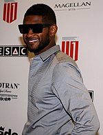 A man is wearing sunglasses and is facing smiling towards the camera.