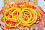 Sliced pickled onions atop a sandwich