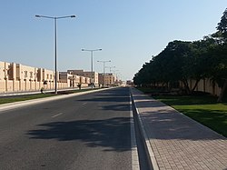 View from the road of a gated community in Mesaieed near Dunes Mall