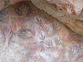 Handabdrücke, zwischen denen sich Abdrücke von Nandu-Pfoten befinden