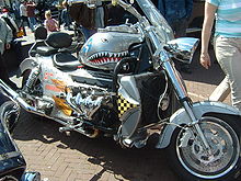 Large silver-colored solo motorcycle with protruding engine and chrome-plated exhaust