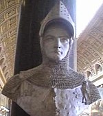 A bust in monochrome grey of a man wearing late-Medieval armour