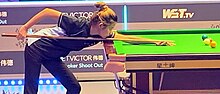 A woman playing snooker