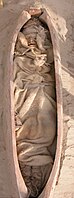 Burial XHM66 from Xiaohe cemetery, with boat-shaped coffin and mummified remains dressed in woollen garments.