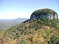 A view in fall of Big Pinnacle from Little Pinnacle Overlook, with Sauratown Mountain and Hanging Rock State Park seen beyond that.