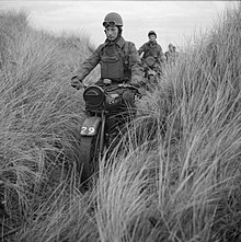 59th Divisional troops, on motorcycles, drive single-file cross country.