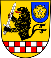 Gemeinde Sulzdorf a.d.Lederhecke In Gold über gesenktem, in zwei Reihen von Rot und Silber geschachtem Balken ein rot bewehrter und rot bezungter schwarzer Löwenrumpf, der ein silbernes Schwert in den Pranken hält, beseitet links oben von einem blauen Schildchen, darin eine goldene heraldische Rose.