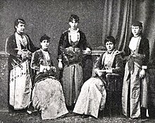 Grainy photograph of women in traditional clothing.