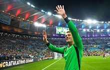 Neuer, in a Germany goalkeeper jersey, waves to fans in a full stadium