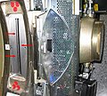 Die roten Pfeile markieren das Strahlaustrittsfenster der Röhre eines 16-Zeilen CTs. Rechts im Bild der Röhrentank; in den oben und unten angeschlossenen Rohrleitungen läuft die Kühlflüssigkeit zur Kühlung der Röhre.