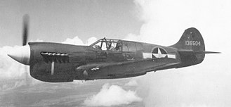 A P-40 Warhawk, a propeller-driven one-seat plane, in flight