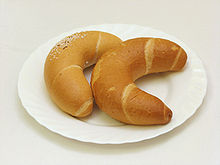 Two crescent-shaped bread rolls on a white plate