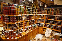 Wooden cabinets and shelves, the latter filled with jars of jams, preserves, and pickled foods
