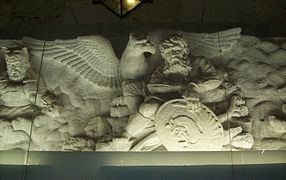 A frieze sculpture scene inside of the tomb depicting the mystical bird simurgh and the hero