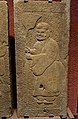 An Eastern Han carved stone tomb door showing a man wearing trousers underneath a long robe with a jinze hat, stored in Sichuan Provincial Museum in Chengdu