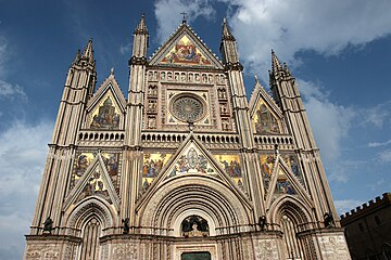 The Gothic façade of Orvieto Cathedral is veneered with polychrome marble, and set, like a reliquary, with colorful mosaics and free-standing statues of marble and bronze.