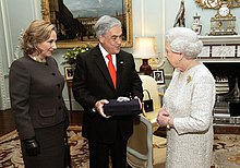 Color image of Chilean President Piñera and the First Lady present a souvenir gift rock from the San Jose Mine to Elizabeth II on 18 October 2010 during a state visit to the UK