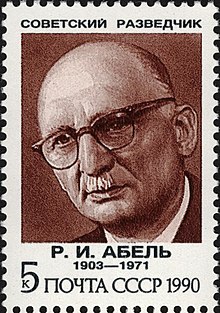 A reproduction of a stamp showing a drawing of a balding elderly man wearing glasses