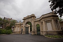 Arched gate with a small lodge to right and left