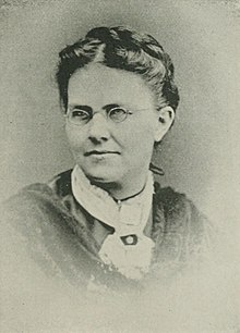 A black-and-white portrait of a woman wearing spectacles